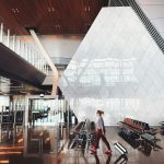 smart-carry-on-packing-guide-airport-travel Smart carry-on packing guide traveler walking through airport with small luggage